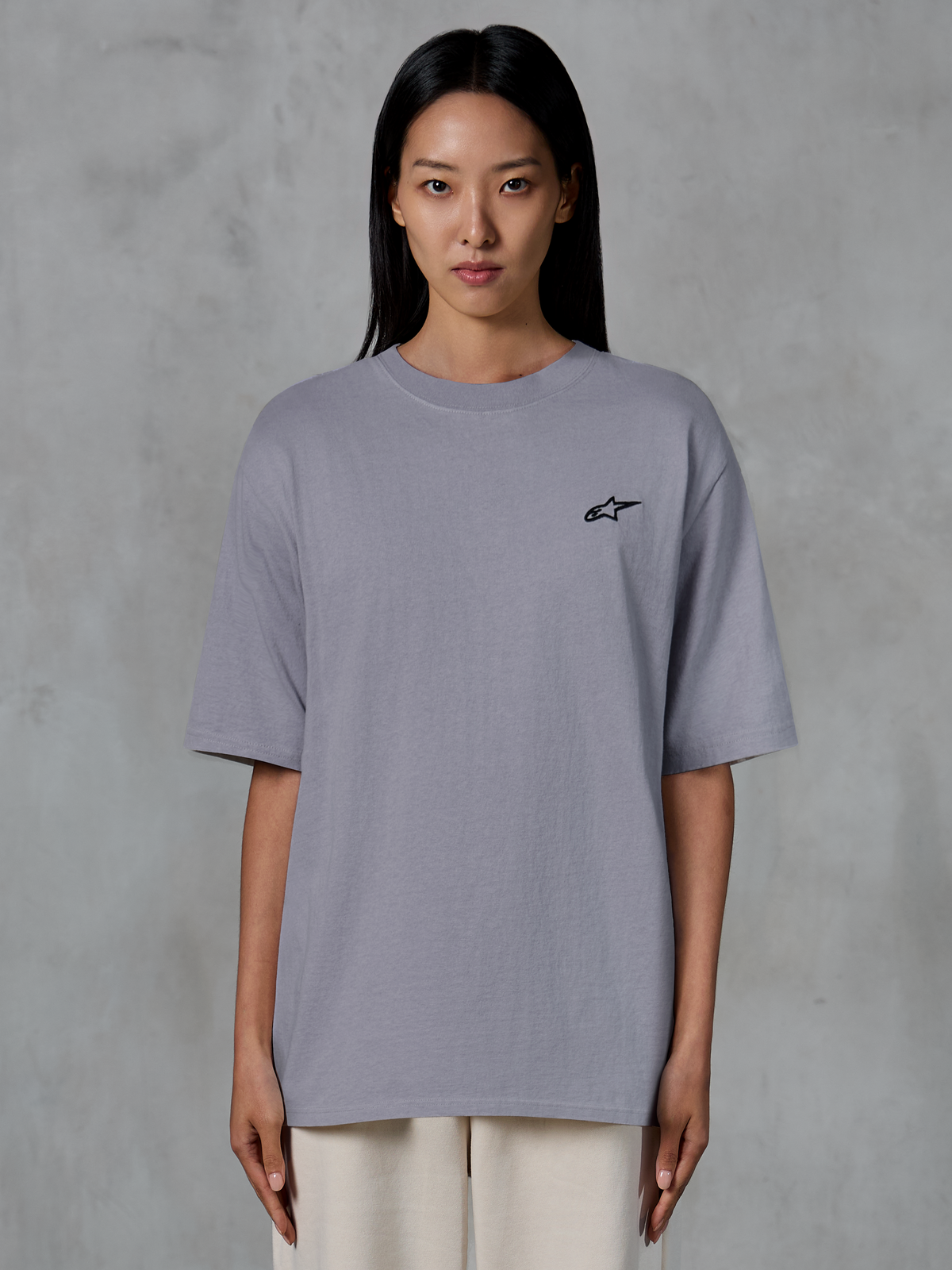 Alpinestars Essentials Ageless SS Tee, Short Sleeve T-Shirt, Silver, featuring a small black Alpinestars logo on the chest, relaxed contemporary fit, organic cotton, casual lifestyle streetwear worn by a model