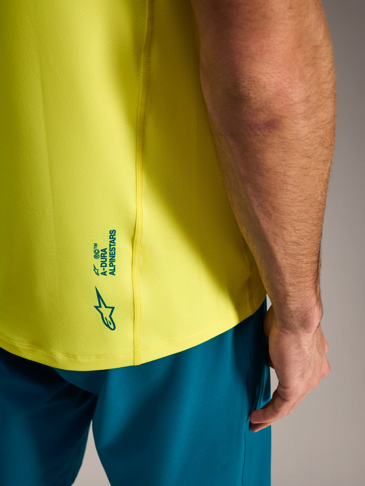 Yellow fluo A-Dura Ride Jersey with Alpinestars branding detail on the lower back, lightweight MTB cycling apparel.