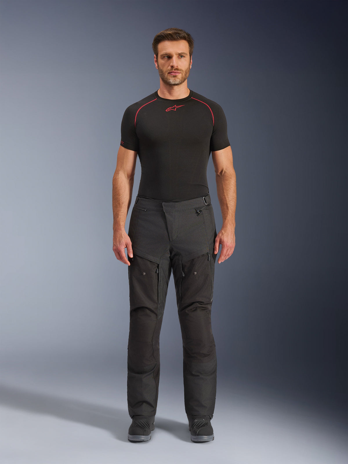 Alpinestars Cusco Drystar® Pants, Textile Motorcycle Pants, Black, worn by a model with a black base layer and boots, adventure touring design with zippered thigh ventilation panels and durable multi-panel construction