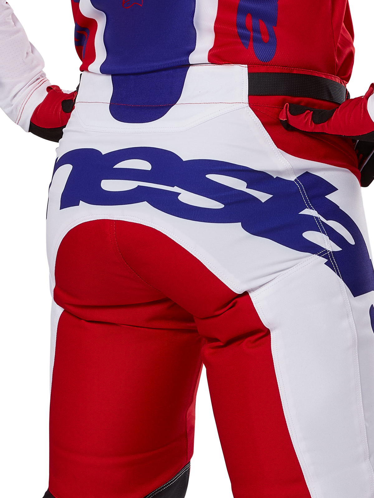 Alpinestars 2025 Racer Veil Pants, Motocross Pants, Bright Red and White with blue branding, back view detail of seat area featuring a large Alpinestars logo, worn as part of a coordinated off-road racing outfit