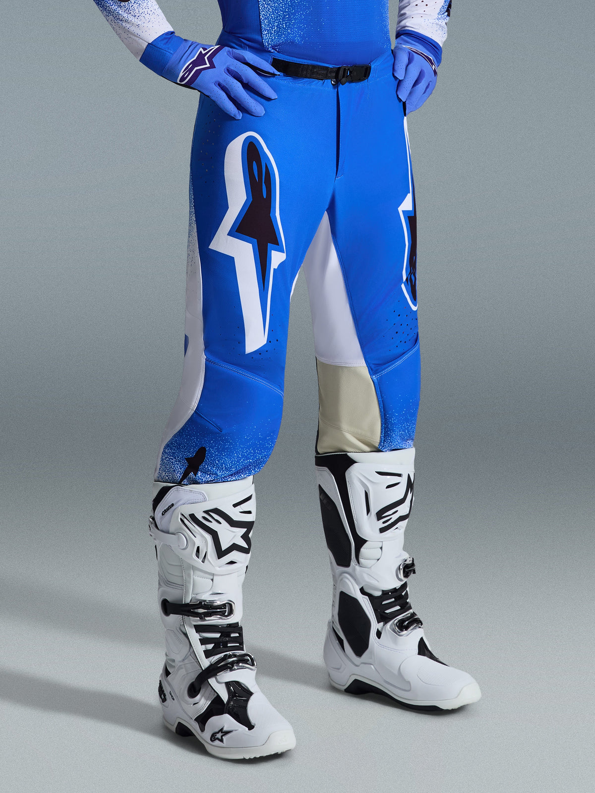 Alpinestars 2026 Supertech Scenz Pants, Motocross Pants, Ucla Blue and White, worn with white and black boots and blue gloves, featuring large graphic logos on the thighs and white panels, athletic fit designed for competitive dirt bike riding