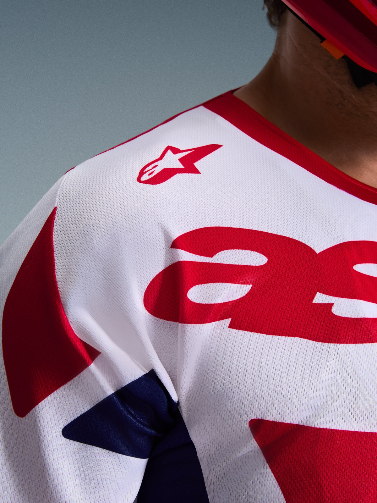 Close-up of Alpinestars 2026 Racer Riway Jersey, Motocross Jersey in White Blue Red, featuring breathable moisture-wicking mesh texture, red star logo on the shoulder, and bold red graphics on the chest