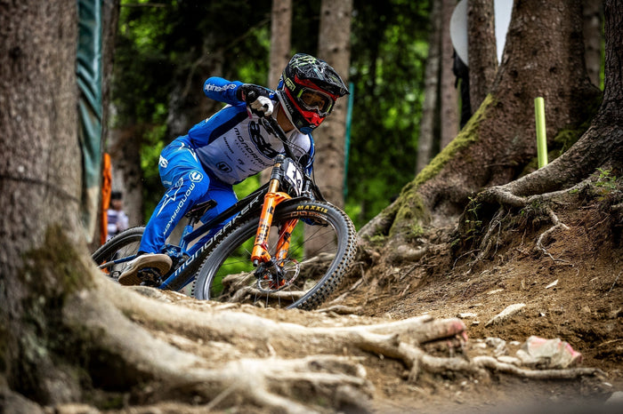 Downhill rider on a tight bend, wearing Alpinestars clothing and protections