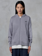 Alpinestars Essentials Ageless Zip Hoodie, Silver, casual streetwear, full-zip fleece sweatshirt with small black Alpinestars logo on chest, split kangaroo pocket, worn by model over white t-shirt and dark jeans