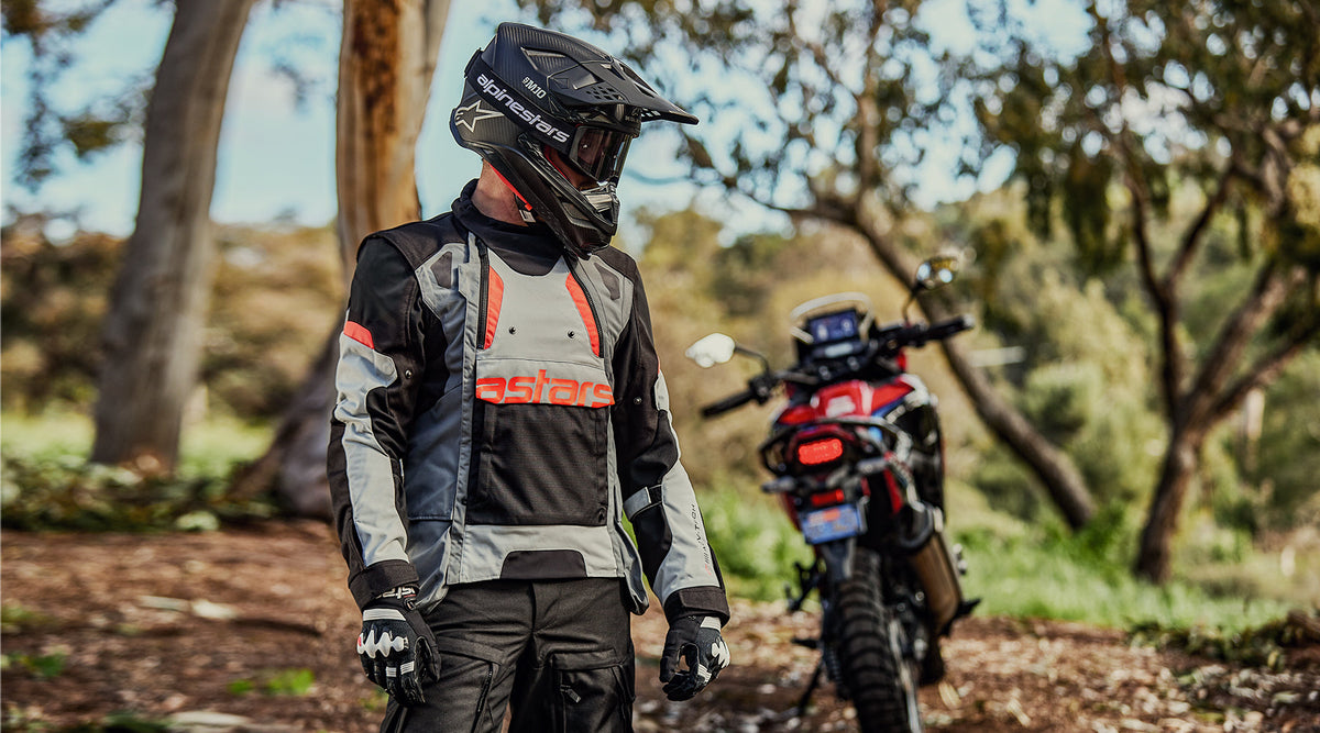 Alpinestars Halo Drystar® Jacket, adventure touring motorcycle jacket in Dark Gray and Ice Gray, on-model on a forest trail.