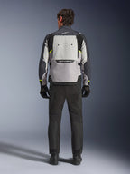 Rear view of a rider wearing the Alpinestars Cusco Drystar® Jacket in Ice Gray, Mid Gray, and Deep Gray, styled with black motorcycle pants and gloves, highlighting the large rear ventilation panel and Alpinestars branding