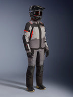 Alpinestars Stella Andes V4 Drystar® Jacket, women's adventure touring textile motorcycle jacket in dark gray, black, and coral fluo, full side profile view on a model wearing matching gear and helmet.