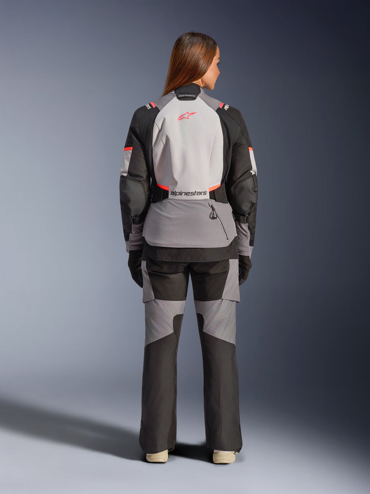 Alpinestars Stella Andes V4 Drystar Jacket and Pants, women's adventure touring gear in dark gray, ice gray, and black, rear view on a model wearing the complete waterproof textile outfit.