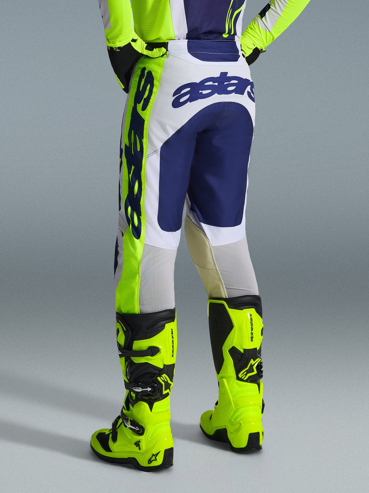 Alpinestars 2026 Racer Air Riway Pants, Motocross Pants, Light Gray Yellow Fluo and Blue, rear view showing bold blue branding on the seat, worn with matching jersey and bright yellow fluo boots, ergonomic race-fit design