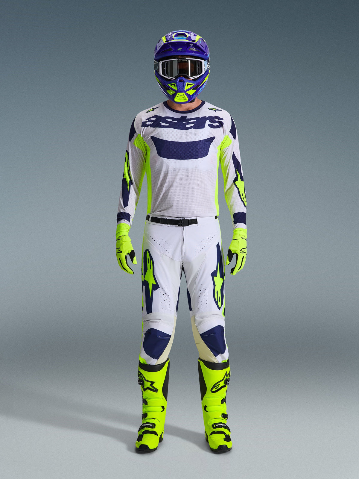 Alpinestars 2026 Racer Air Riway Pants, Motocross Pants, Light Gray with Yellow Fluo and Blue, worn by a rider in a full racing kit including matching white jersey, fluorescent yellow boots and gloves, and a blue helmet, professional off-road racing gear