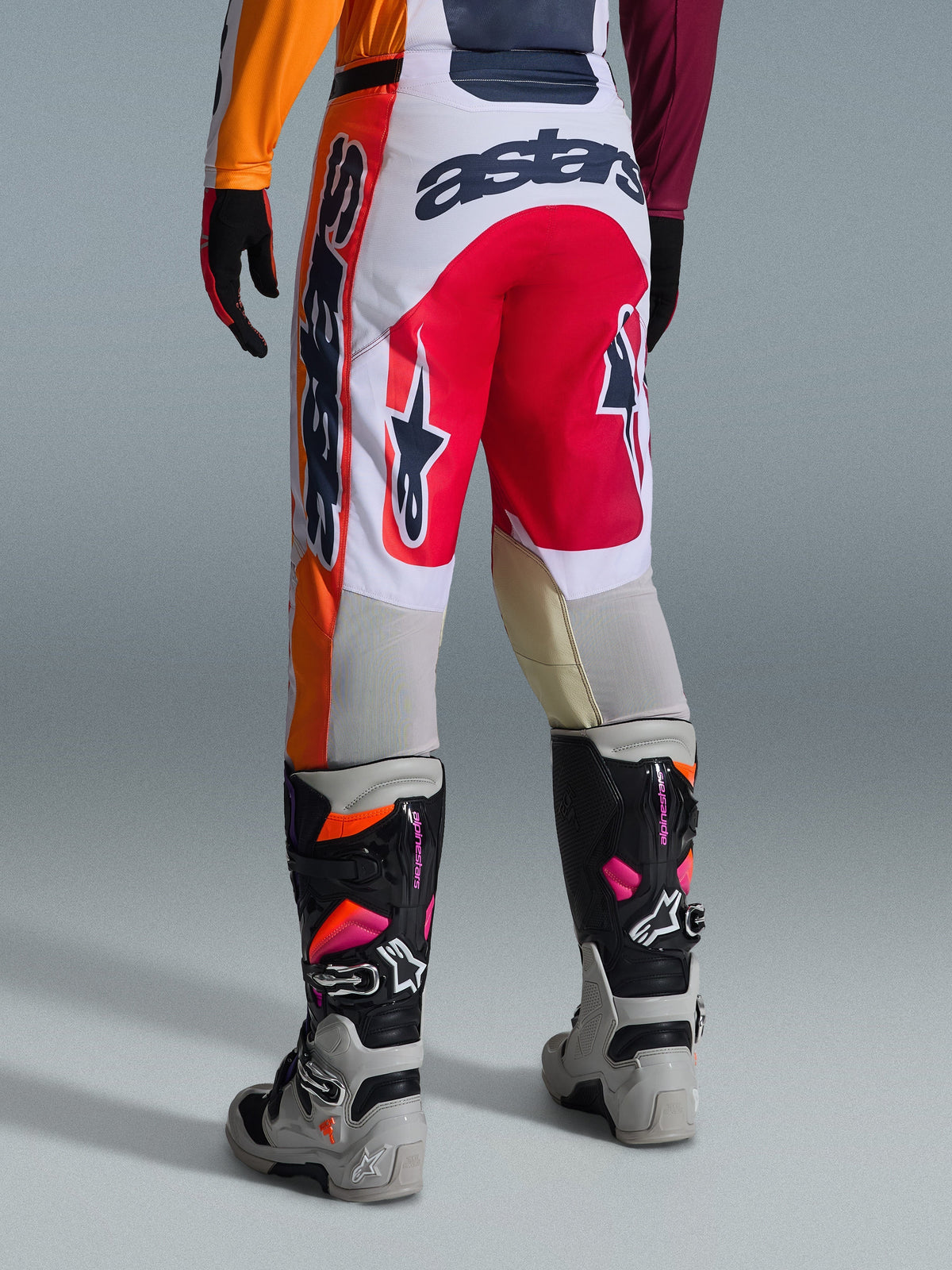 Alpinestars 2026 Racer Portl Pants, Motocross Pants, Red, Light Gray and Dark Gray, back view featuring bold branding and logo details, paired with coordinated motocross boots and gloves, performance gear for off-road racing.