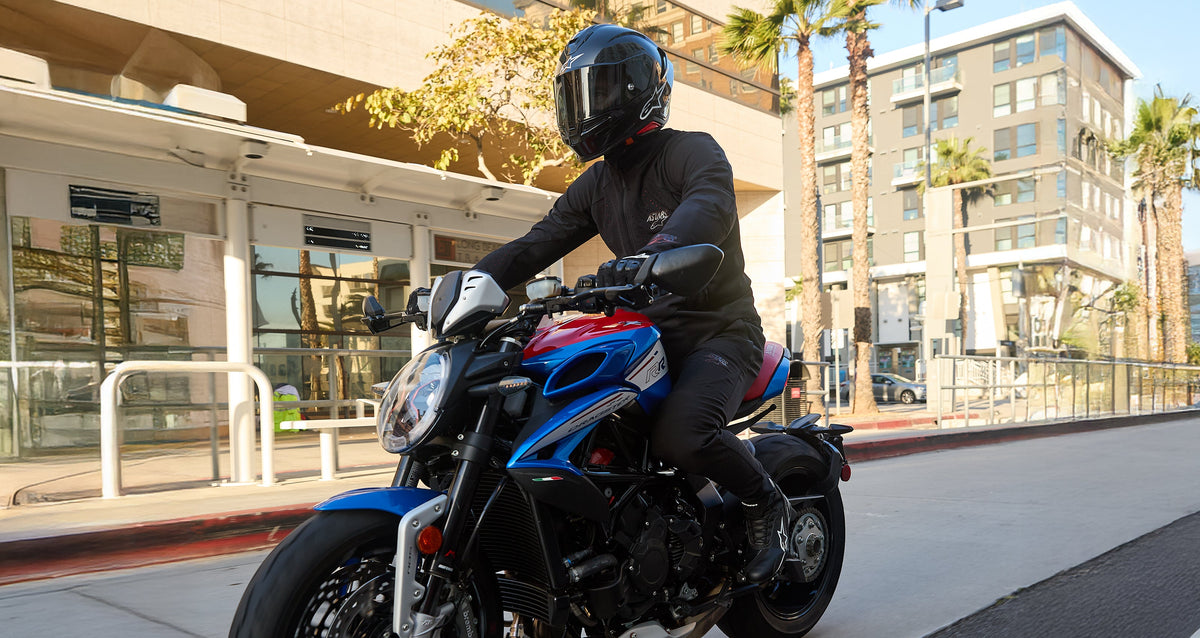 Alpinestars Aeroshell Airflow Pants, Gray ventilated motorcycle pants, worn by a man riding a blue and red sport bike.