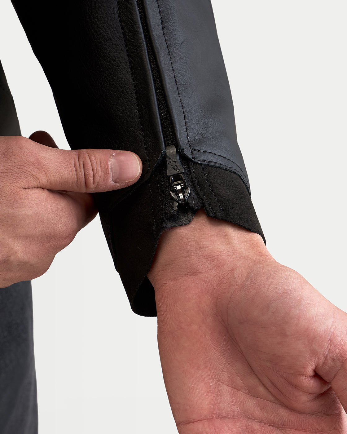 Alpinestars Caliber V2 Leather Jacket, close-up view of the sleeve cuff zipper detail, black leather construction, highlighting ergonomic design and premium performance features