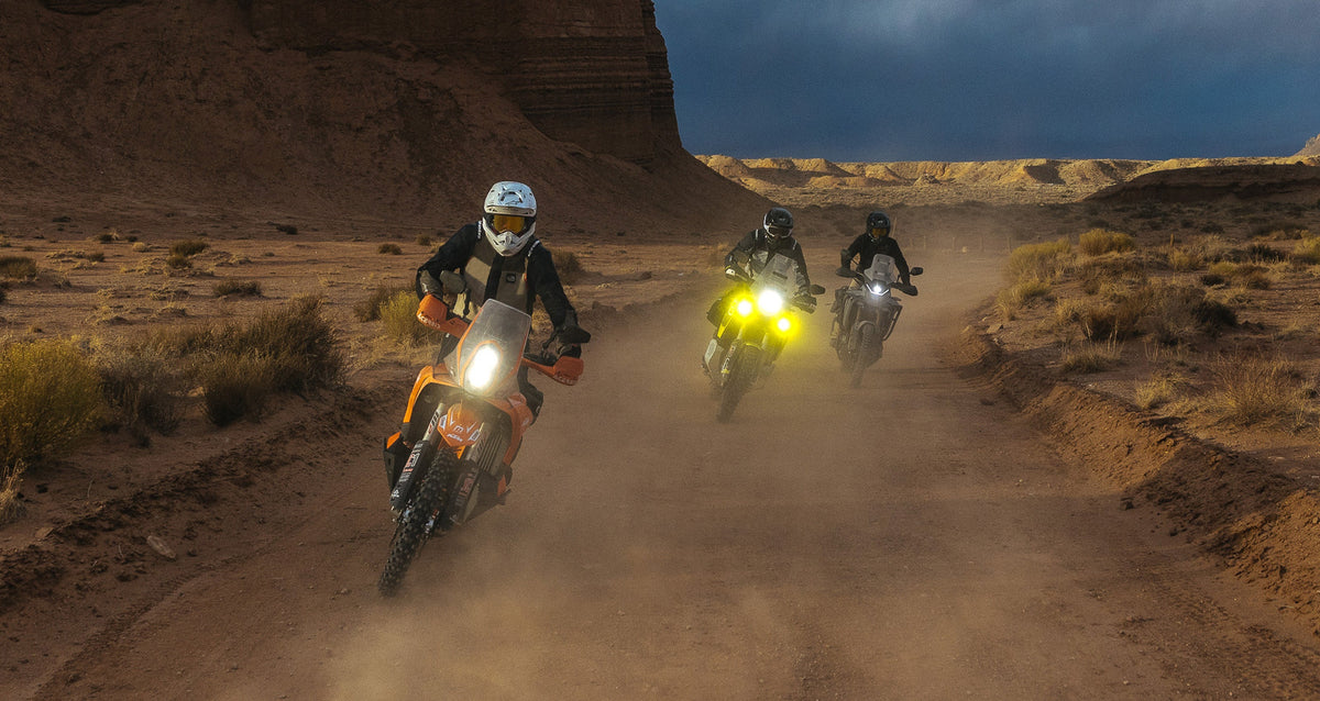 Alpinestars Andes Pro Drystar® XF Pants, men's adventure touring pants, black and gray, on riders in a dusty desert trail.