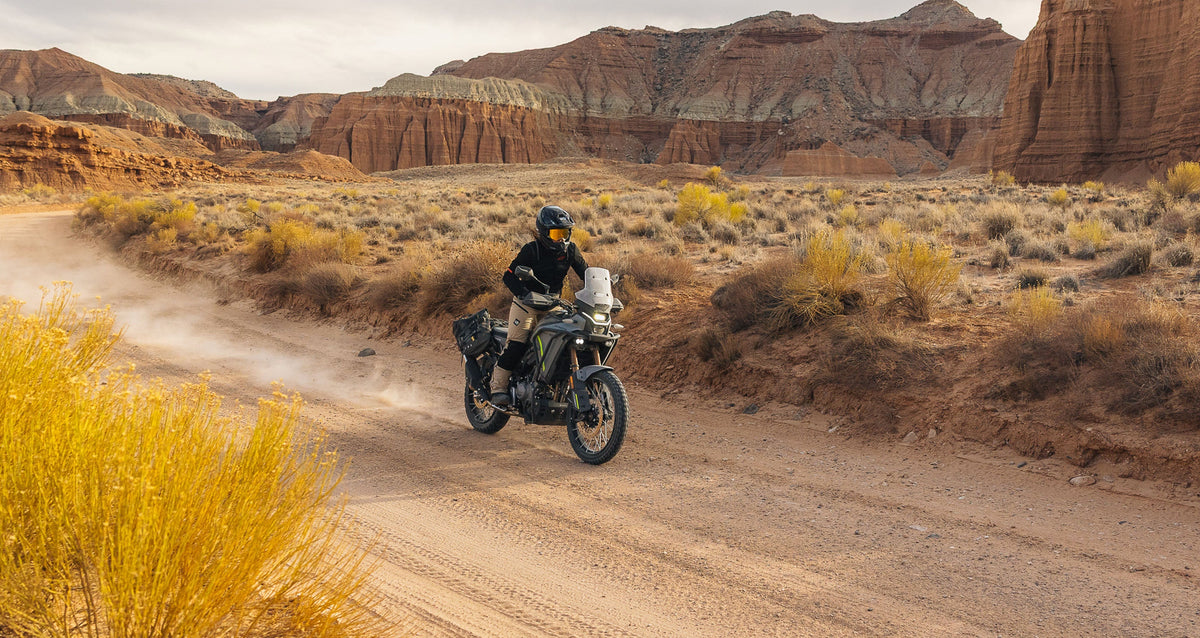 Alpinestars Stella Flex-AST and Explore AST Pants, tan women's motorcycle gear for adventure touring in a dusty desert.