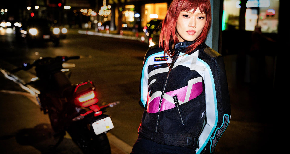 Alpinestars Idles Women's Jacket, urban textile motorcycle jacket, Black and Purple, vintage racing style, on model at night.