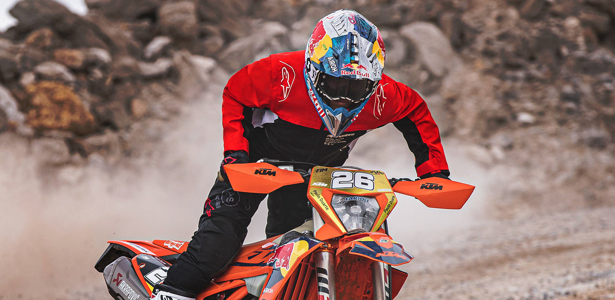 Alpinestars Pro-Dura Jacket, red and black off-road textile jacket for enduro riding, shown in action on a motorcycle.
