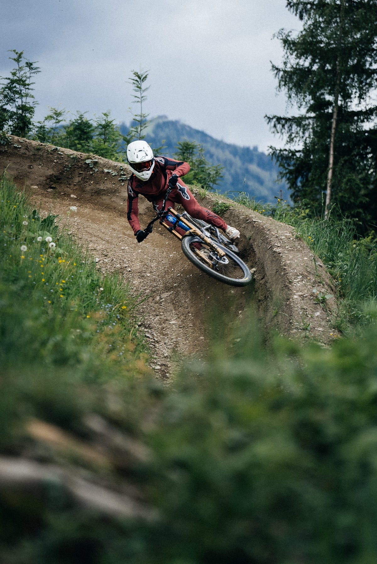 Alpinestars A-Supra Race Jersey and Pants, burgundy MTB gear, on-model racing action on a dirt track berm.