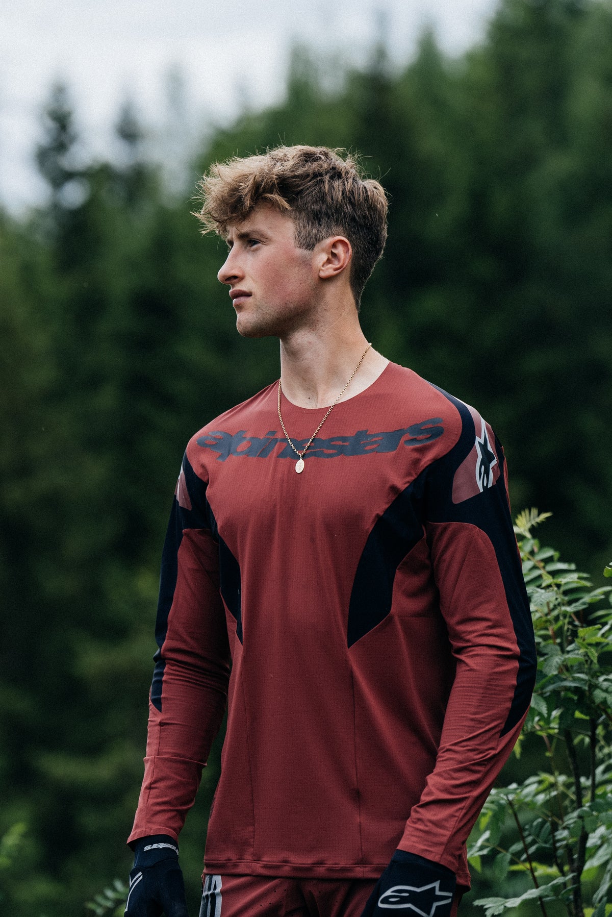 Alpinestars A-Supra Race Jersey and Pants in Burgundy and Black, performance MTB kit on a male rider outdoors.