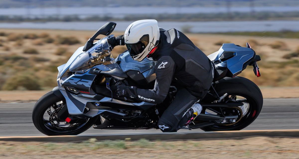 Alpinestars SP-9 Gloves in black, leather motorcycle racing gloves worn by a rider cornering on a track.