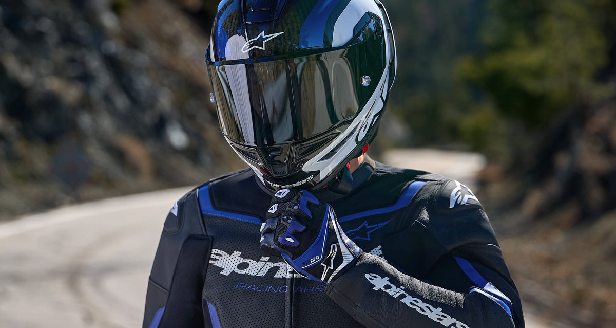 Alpinestars SP-R Pro Gloves in blue and black, worn with a leather racing suit and helmet for sport motorcycle riding.