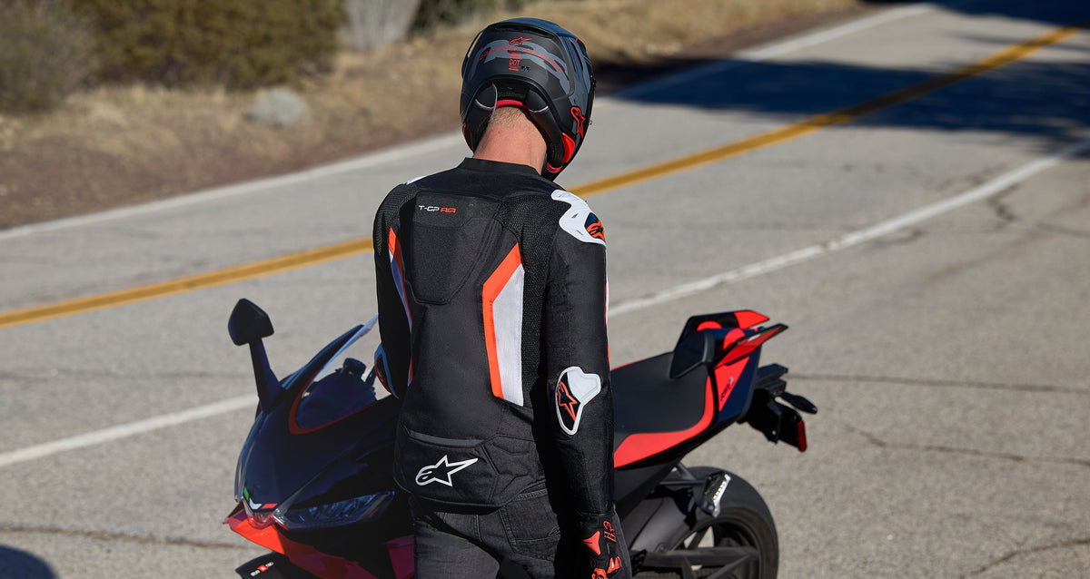 Alpinestars T-GP Air Jacket, men's sport motorcycle racing jacket, black and red with aero hump, shown on a rider.