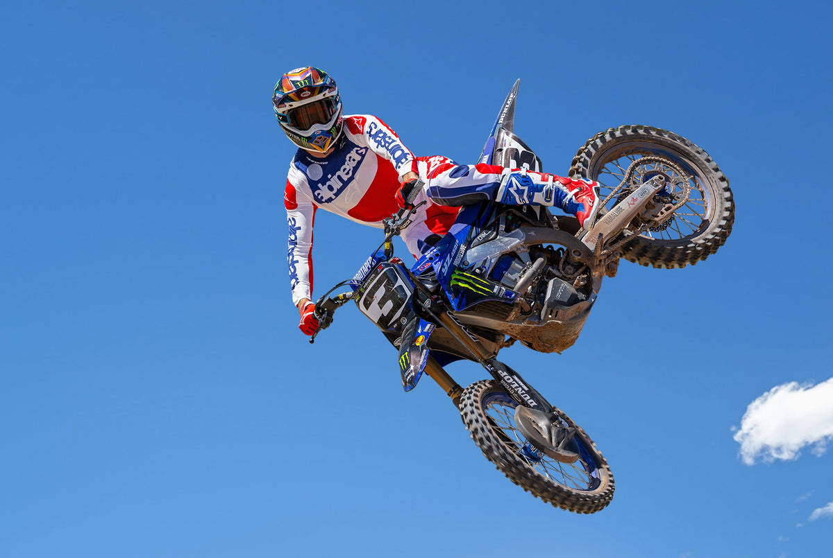 Alpinestars Limited Edition Techstar Fortitude Pants, Red and Blue Men's Motocross Gear, worn by a rider mid-jump.