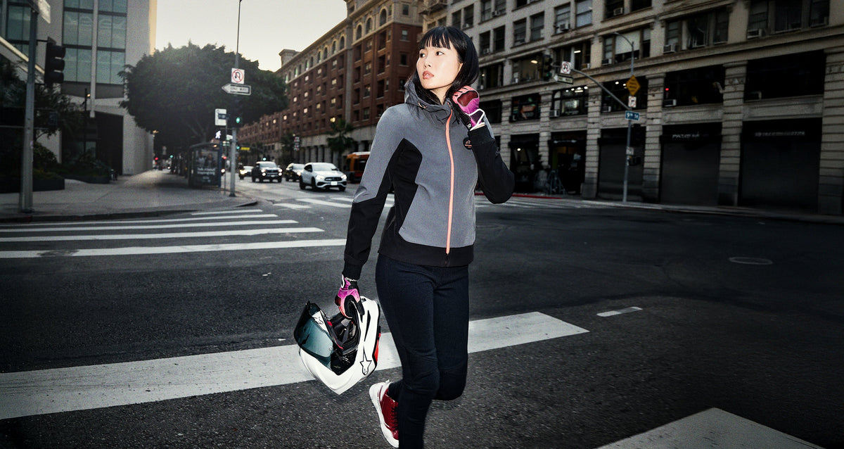 Alpinestars Stella Radium Tech Hoodie, women's gray and black windproof motorcycle hoodie, urban riding gear on city street.