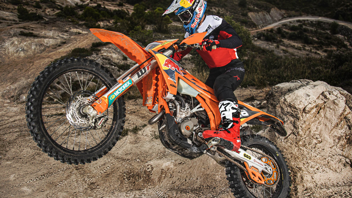 Alpinestars Tech 10 Enduro Boots in Red and White, professional off-road motorcycle racing boots shown in action on a rider.
