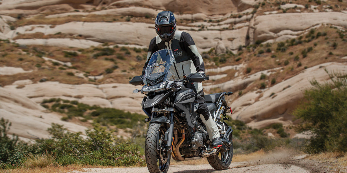 Alpinestars AMT-7 Air Pants, adventure touring textile pants, black and gray, worn by a rider in a rocky desert landscape.